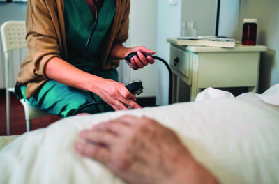 Caregiver checking blood pressure to a senior woman